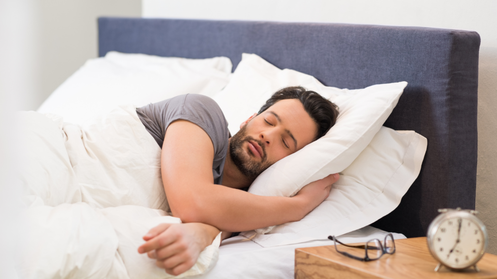 Sleep information feature image with man asleep in bed next to clock showing 7am
