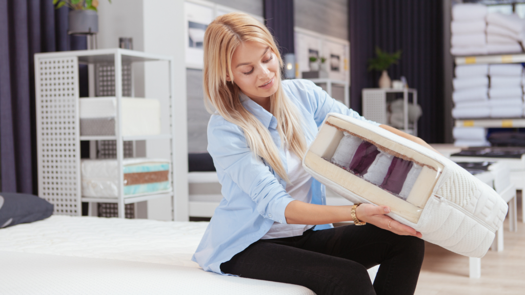 Lady looking at a sample of a mattress and how it is made