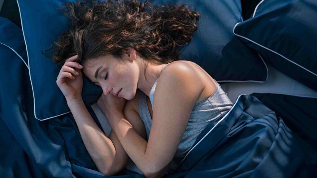 Woman asleep in bed thanks to high sleep drive.