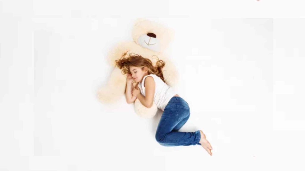 Child asleep on a teddy
