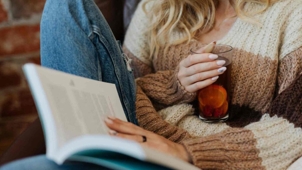 Woman holding a drink and reading